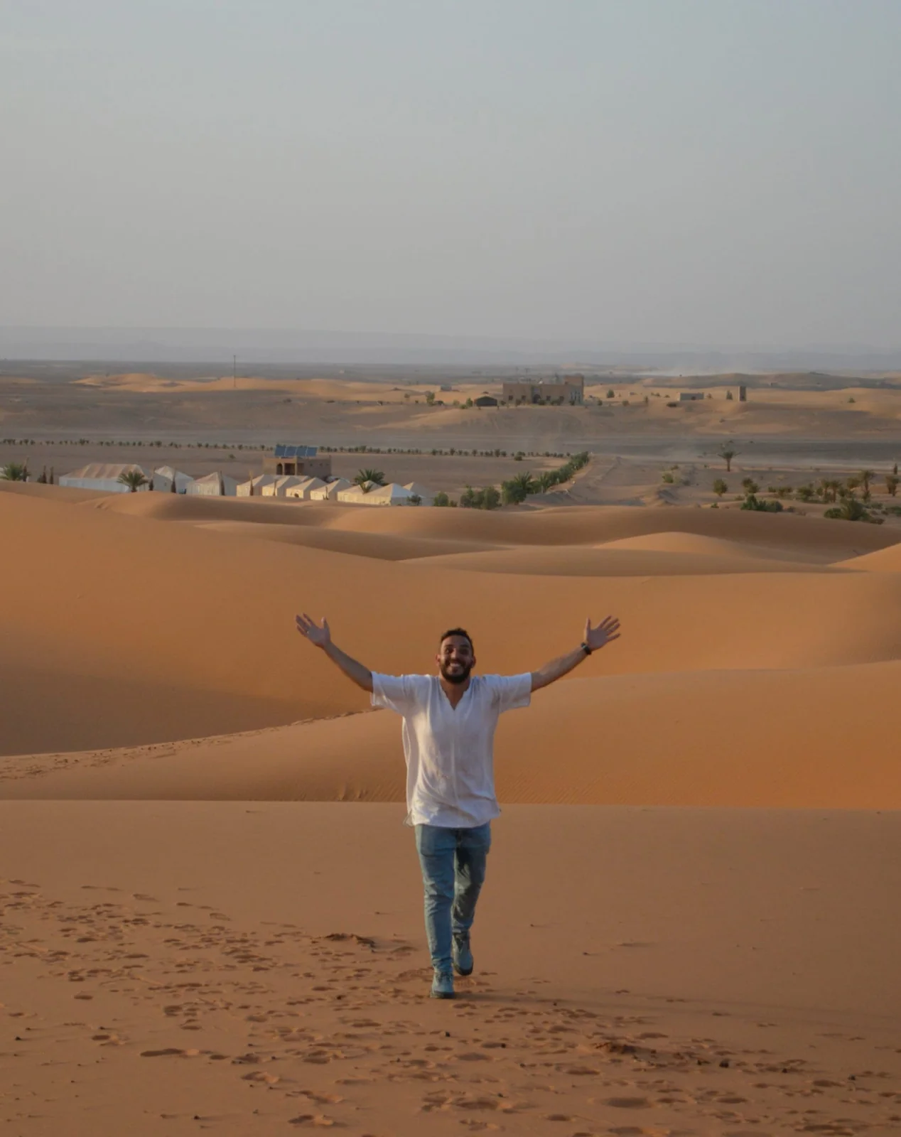 Abdel, founder of Morocco Travelogue, with open arms in the Sahara dunes